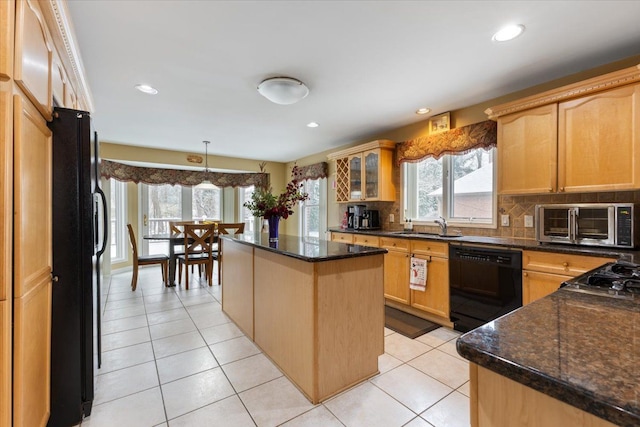 kitchen with tasteful backsplash, dark stone counters, sink, black appliances, and a center island