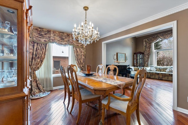 dining area with hardwood / wood-style floors, an inviting chandelier, and ornamental molding