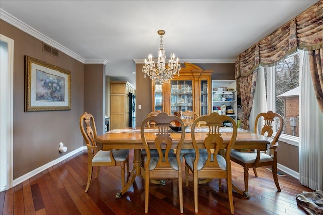 dining area featuring a chandelier, wood-type flooring, and ornamental molding