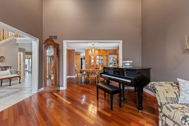 misc room with a high ceiling, hardwood / wood-style flooring, and an inviting chandelier