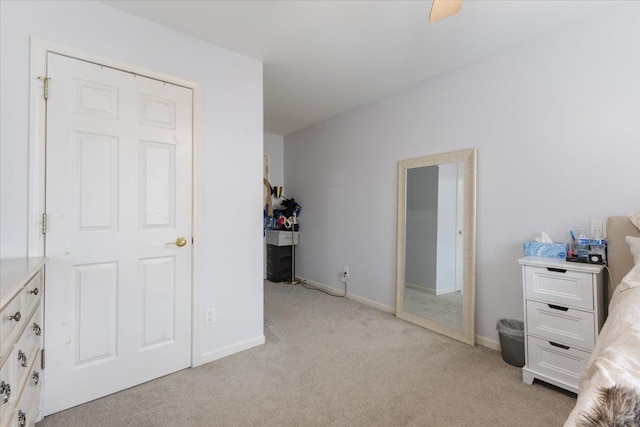 bedroom featuring ceiling fan, light carpet, and a closet