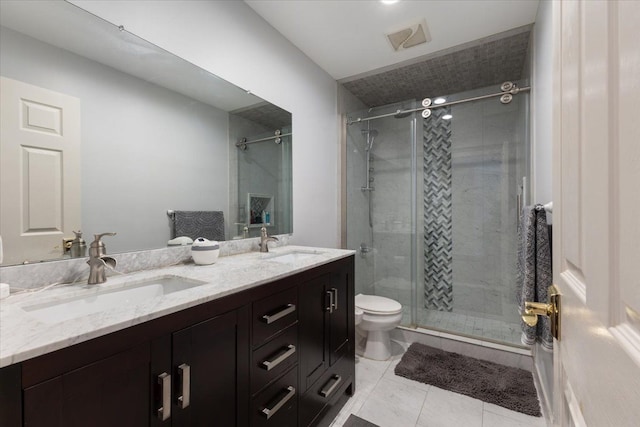 bathroom featuring toilet, vanity, tile patterned floors, and a shower with door