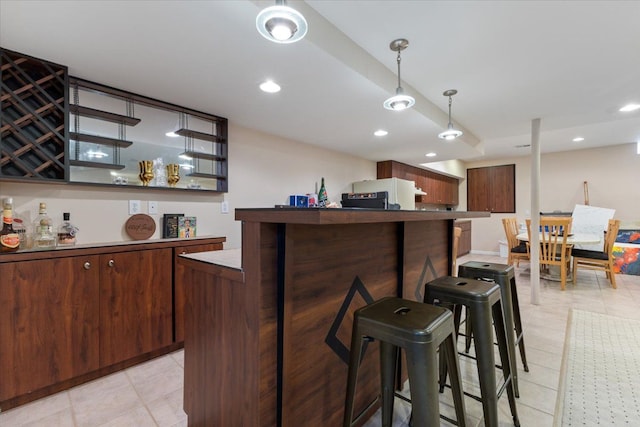 bar with dark brown cabinetry and hanging light fixtures