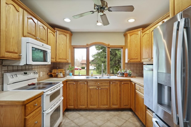 kitchen with tasteful backsplash, sink, light tile patterned flooring, and white appliances