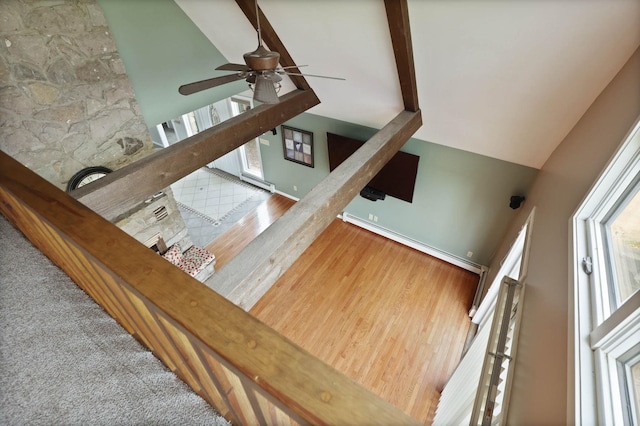 staircase featuring baseboard heating, ceiling fan, carpet floors, and a healthy amount of sunlight