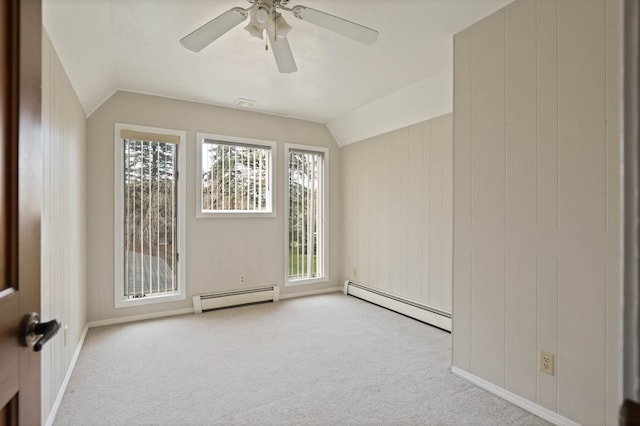 empty room with light colored carpet, a baseboard radiator, and lofted ceiling