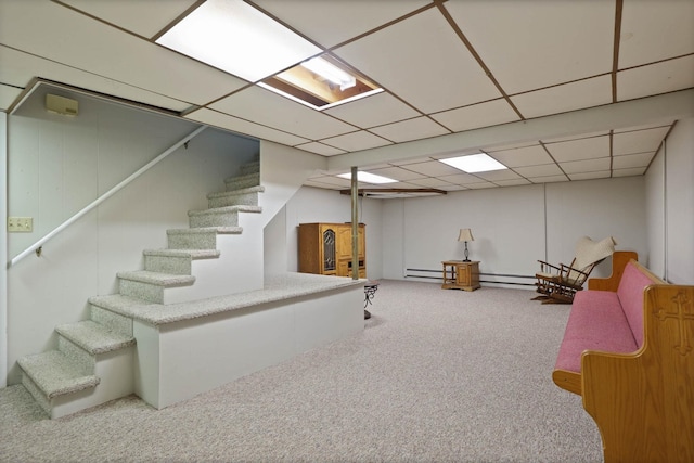 basement featuring carpet flooring, a paneled ceiling, and a baseboard radiator