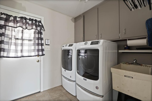 laundry area featuring washer and clothes dryer, light tile patterned flooring, cabinets, and sink