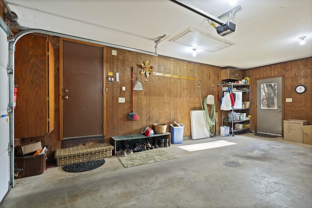 garage with wood walls and a garage door opener