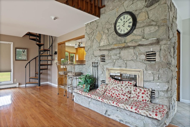 unfurnished living room featuring a stone fireplace, a wealth of natural light, and light hardwood / wood-style floors