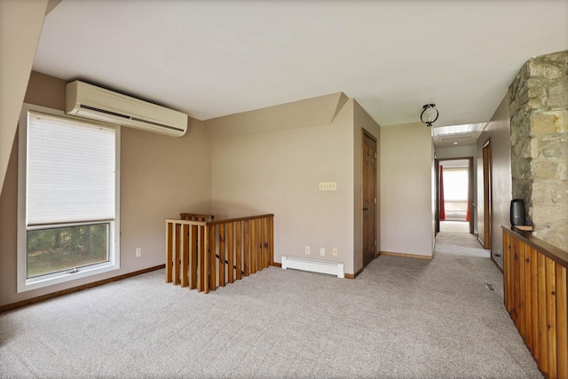 empty room featuring light colored carpet, a wall unit AC, and a baseboard heating unit