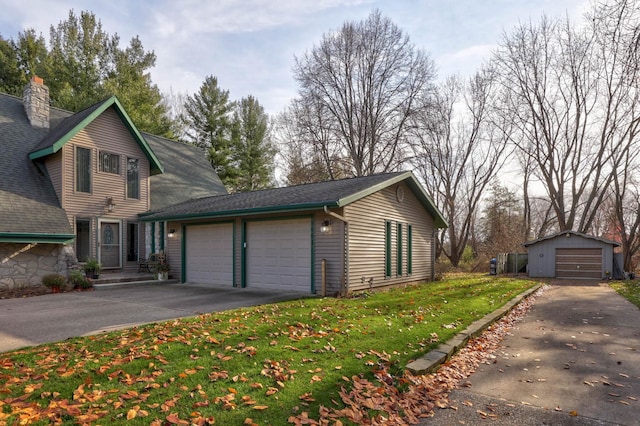 view of side of property with a garage, an outdoor structure, and a yard