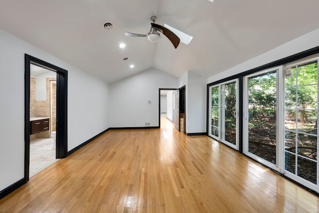 interior space with light hardwood / wood-style flooring, ceiling fan, and lofted ceiling with skylight