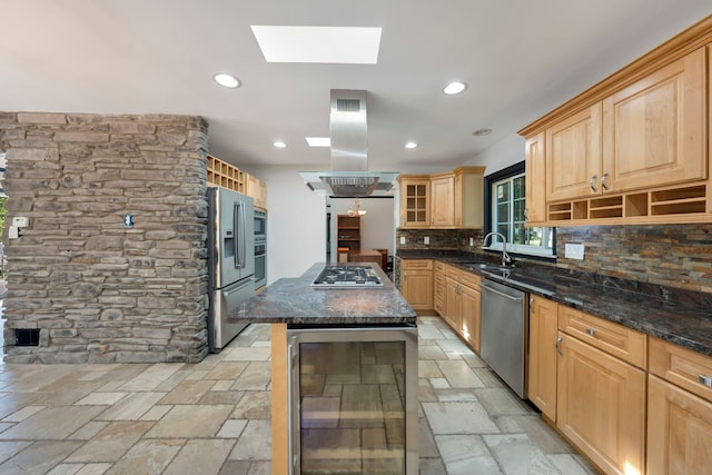 kitchen with a skylight, a center island, wine cooler, island exhaust hood, and appliances with stainless steel finishes