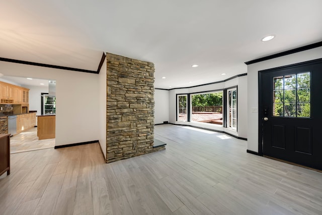 foyer with light hardwood / wood-style floors, a wealth of natural light, and ornamental molding