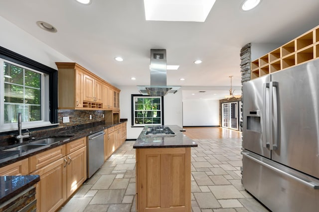 kitchen featuring a center island, a wealth of natural light, island range hood, and appliances with stainless steel finishes