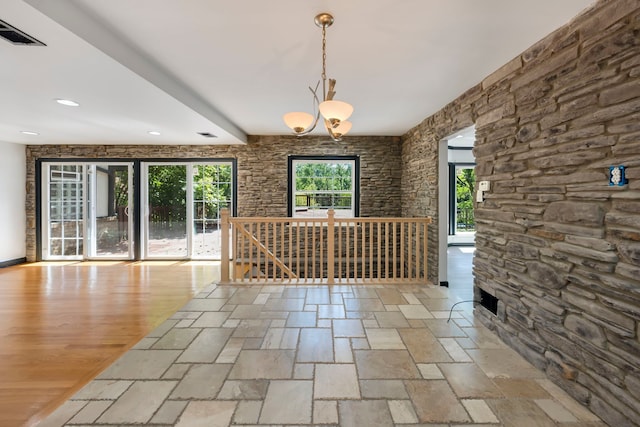 unfurnished dining area with a chandelier and light hardwood / wood-style floors