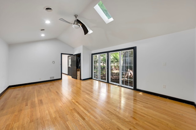 unfurnished living room with ceiling fan, light hardwood / wood-style flooring, and vaulted ceiling with skylight