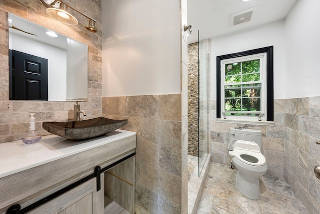 bathroom with vanity, toilet, tile walls, and walk in shower