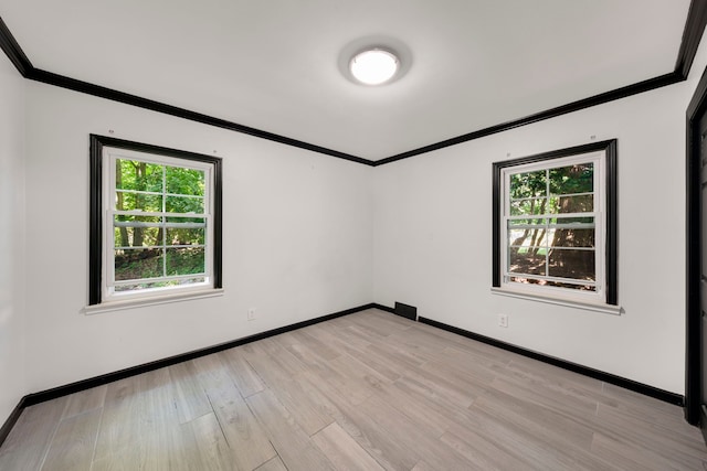 unfurnished room with plenty of natural light, crown molding, and light hardwood / wood-style flooring