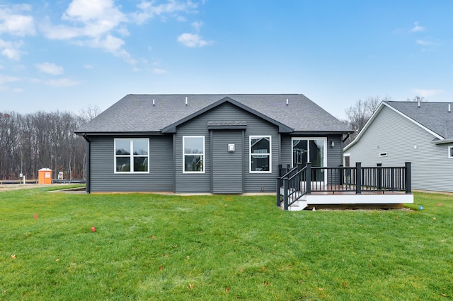 back of house featuring a yard, a shingled roof, and a wooden deck