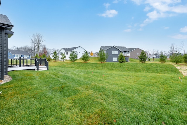 view of yard featuring a residential view and a deck