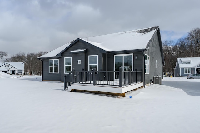 snow covered house with central AC and a wooden deck