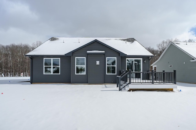 snow covered house featuring a deck