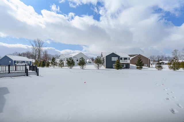 yard layered in snow featuring a residential view