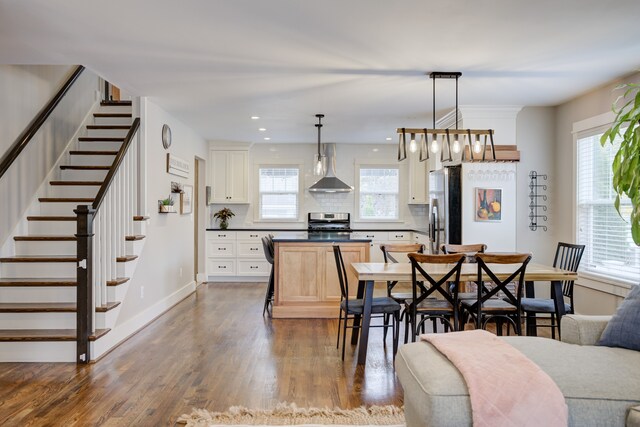 dining room with hardwood / wood-style flooring and a healthy amount of sunlight