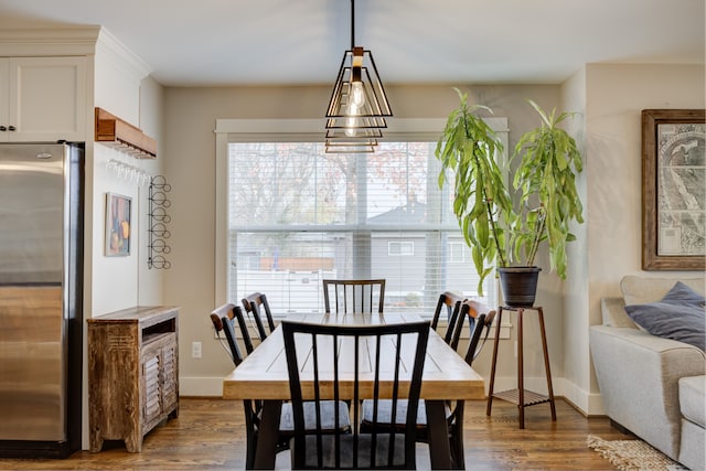 dining space with dark hardwood / wood-style floors and an inviting chandelier