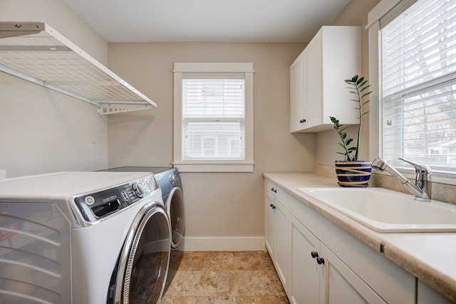 clothes washing area featuring cabinets, independent washer and dryer, and sink