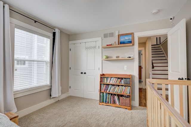 bedroom with light carpet and a closet