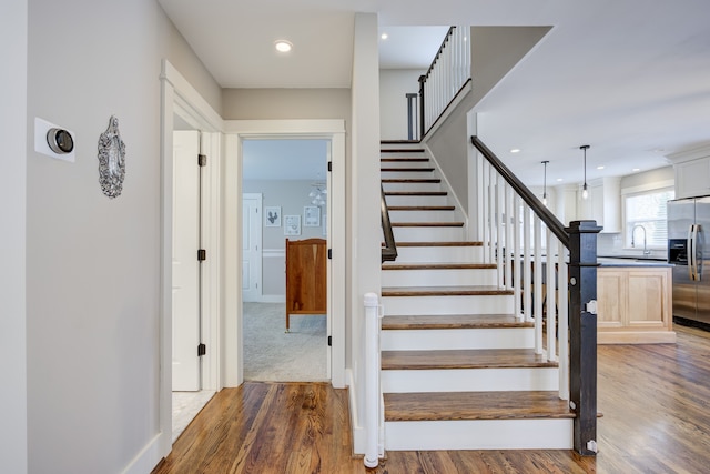 stairway featuring hardwood / wood-style floors and sink