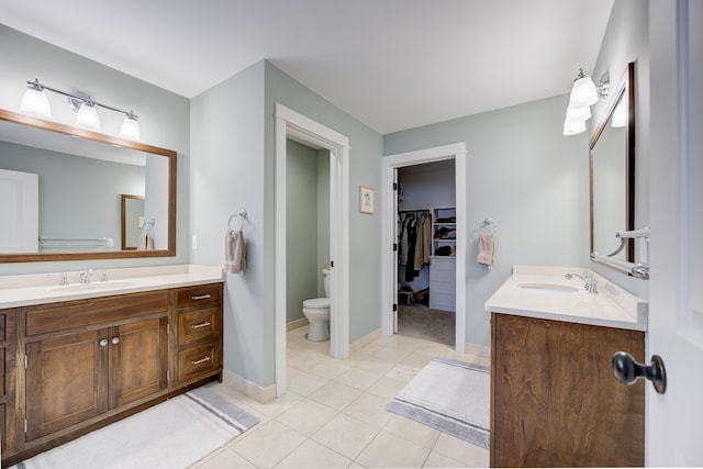 bathroom featuring tile patterned flooring, vanity, and toilet