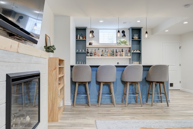 kitchen featuring decorative light fixtures, light hardwood / wood-style floors, and a breakfast bar area