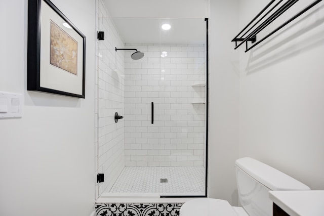 bathroom featuring vanity, a shower with shower door, and toilet