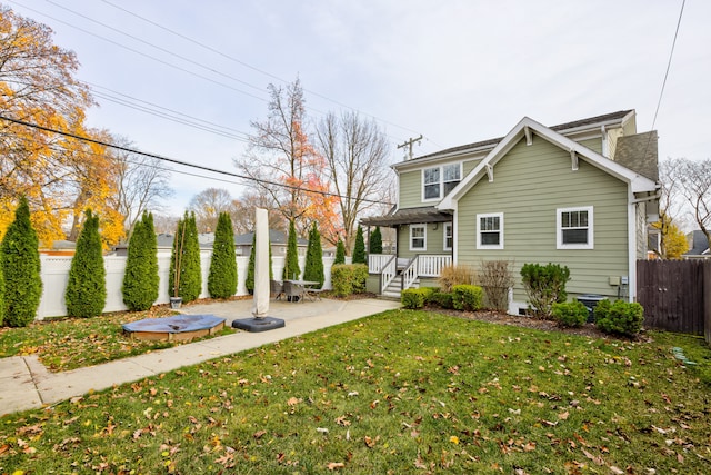 rear view of house with a yard and a patio area