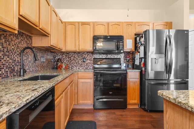 kitchen with dark hardwood / wood-style flooring, tasteful backsplash, light stone counters, sink, and black appliances