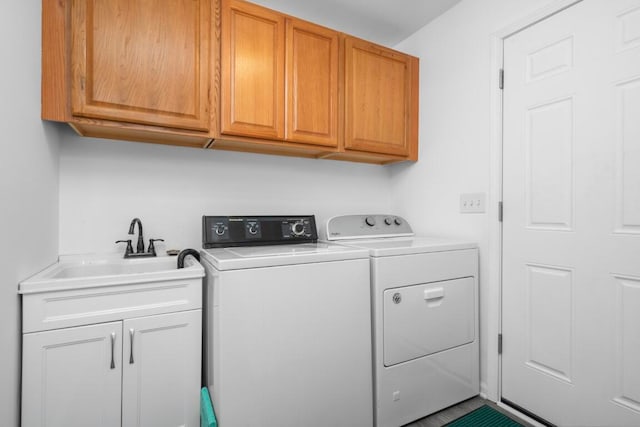 clothes washing area featuring cabinets, independent washer and dryer, and sink