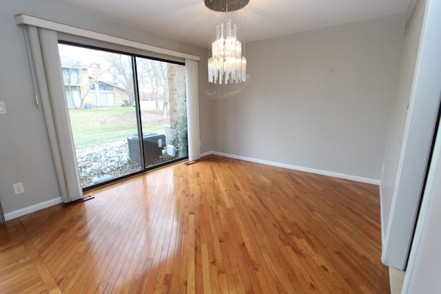 unfurnished room featuring light hardwood / wood-style flooring and a chandelier