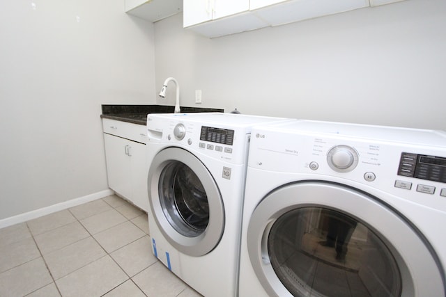 washroom featuring light tile patterned flooring, cabinets, independent washer and dryer, and sink