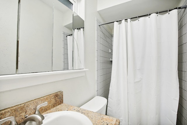 bathroom with a shower with curtain, toilet, and vanity