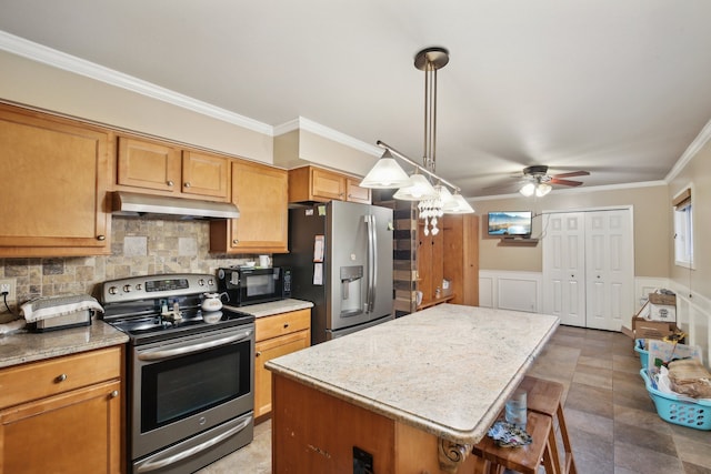 kitchen with a breakfast bar, crown molding, decorative backsplash, a kitchen island, and stainless steel appliances