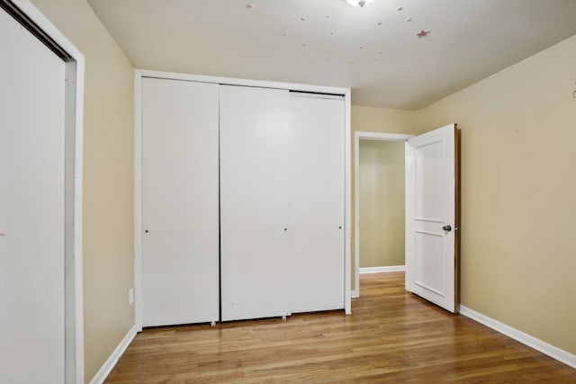 unfurnished bedroom with a closet and light hardwood / wood-style flooring