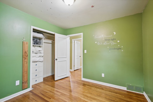 unfurnished bedroom with a closet and light hardwood / wood-style flooring