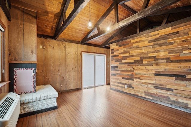 unfurnished room featuring hardwood / wood-style floors, lofted ceiling with beams, and wood walls