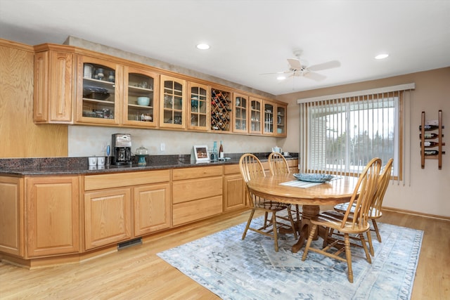 dining space with light hardwood / wood-style floors and ceiling fan