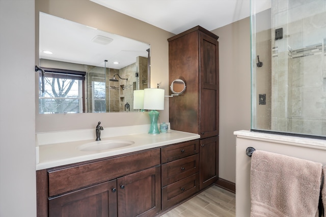 bathroom featuring wood-type flooring, a shower with shower door, and vanity