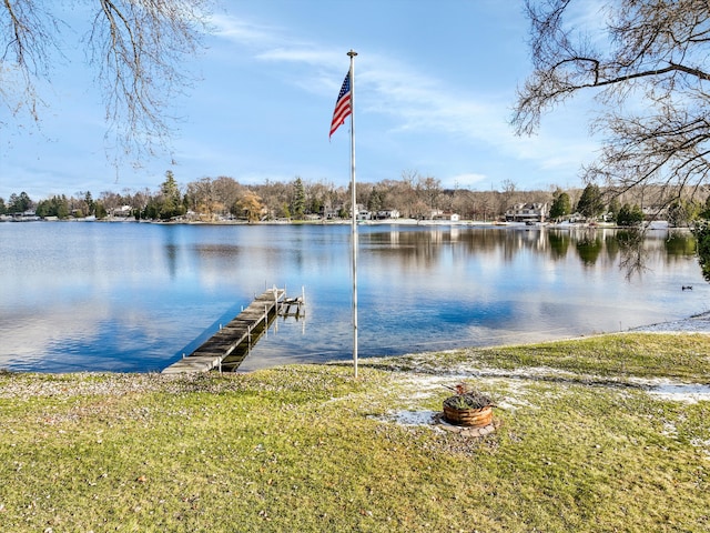 view of dock with a yard and a water view